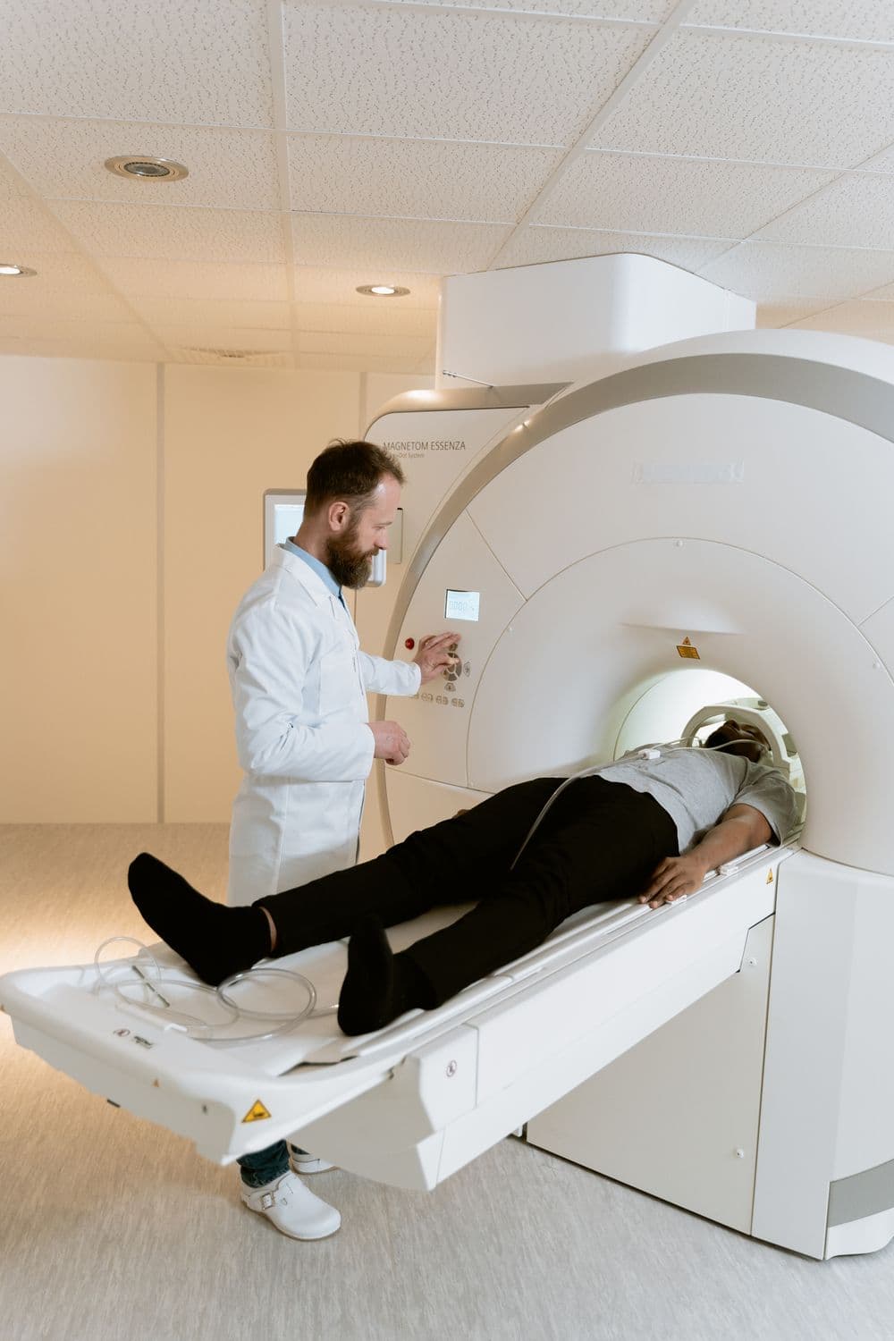 A patient positioned at a scanner with the physician alongside.
