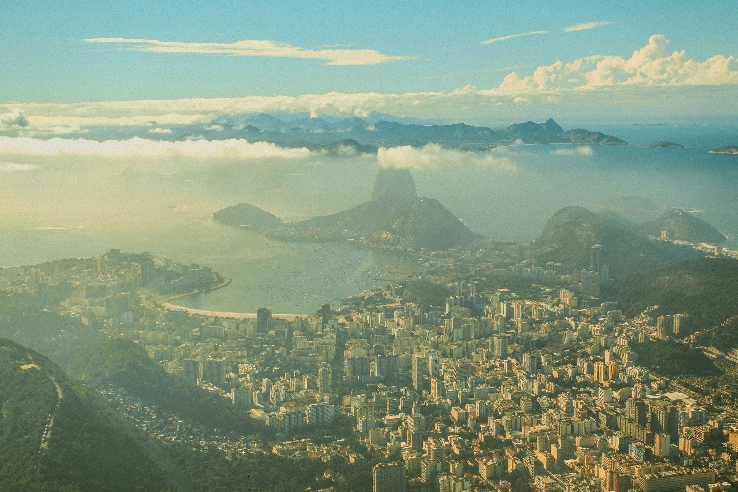 Rio de Janeiro from the air: Sugarloaf Mountain rising over Guanabara Bay, the city spread along the shore below.