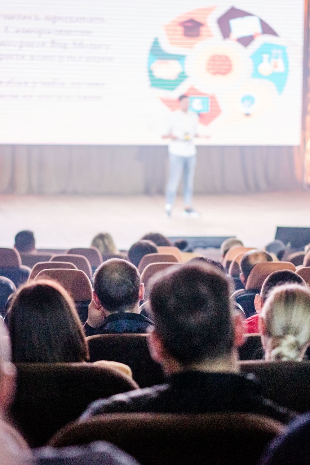 A large congress audience in a lit auditorium.